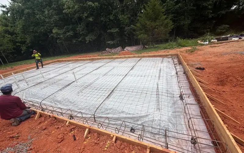 Crew tying rebar grid for a building foundation slab, Yadkin County NC