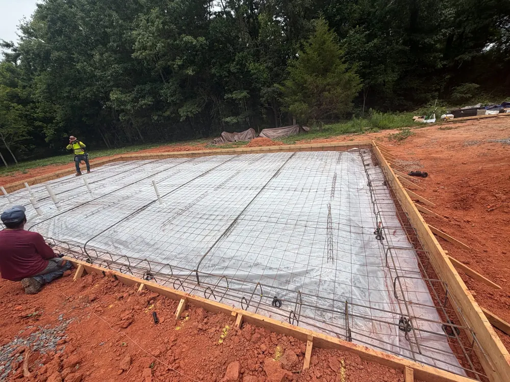 Crew tying rebar grid for a building foundation slab, Yadkin County NC