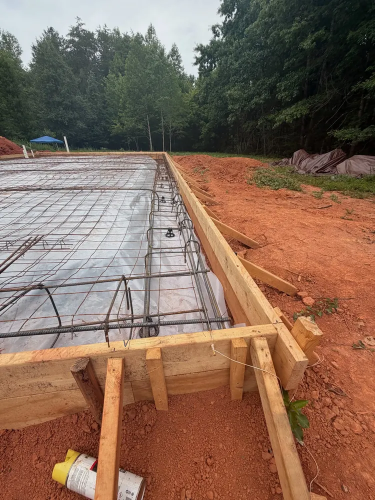 Tied rebar footing cage over vapor barrier in wood forms, Yadkin County NC