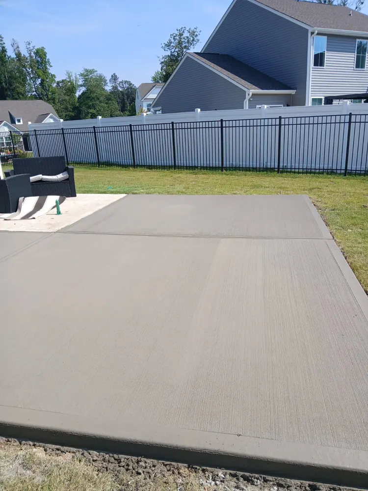 Broom-finish concrete patio along a black fence, Yadkin County NC